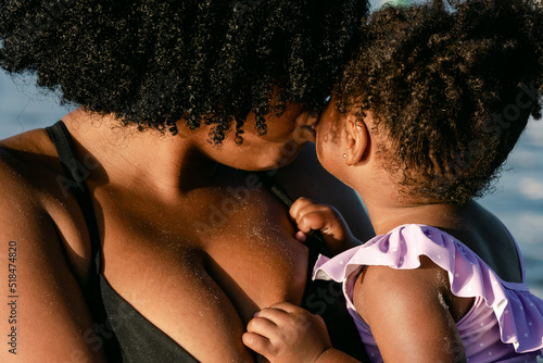 Mom gives big kiss to daughter photo