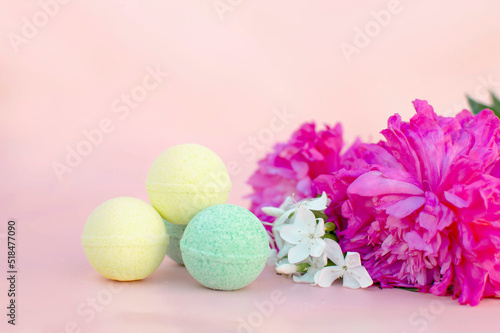 SPA composition with bath bombs and two peonies on a pink background. Close-up. Copy the space for the text. The concept of therapy. I'm taking a relaxing bath.Homemade spa products