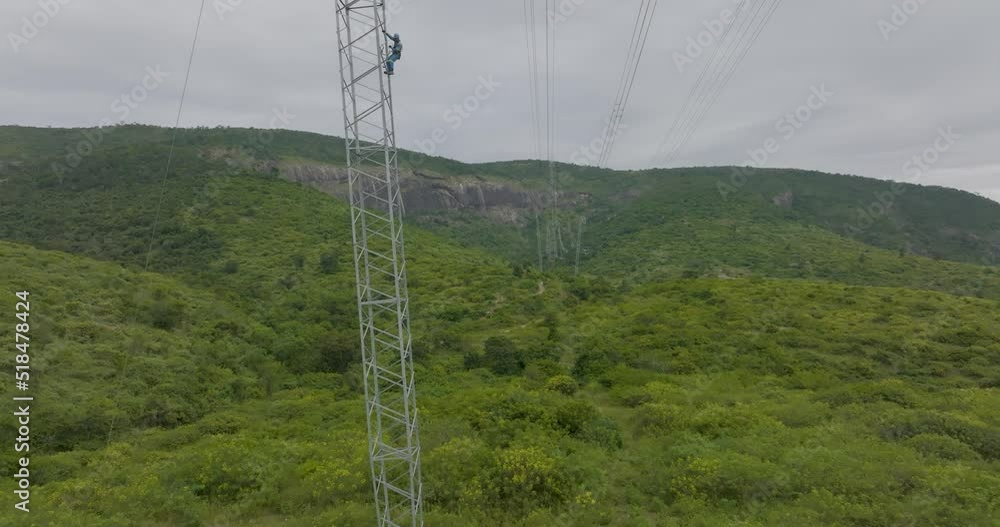 Aerial approaching worker descending metal structure of high voltage tower Aerial approaching worker descending metal structure of high voltage tower
