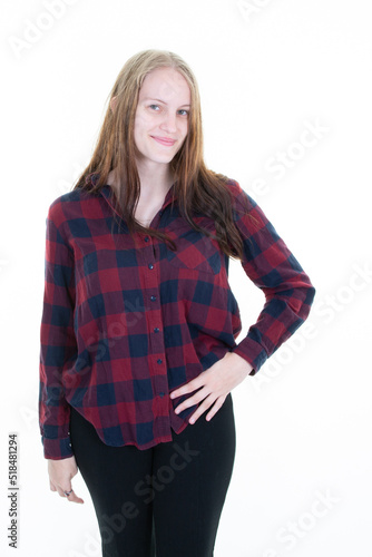 young woman standing with hand on hip in checkered shirt