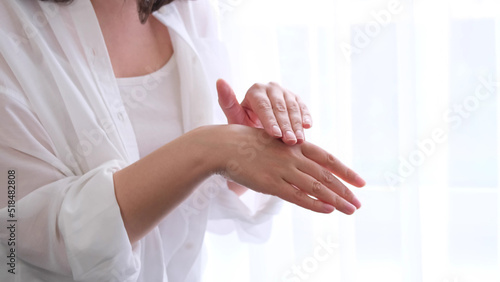 lady runs gently over her hand  enjoying the softness of the skin after using the cream. the concept of self-care  self-love.