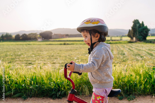 Little girl riding a bicycle in nature 