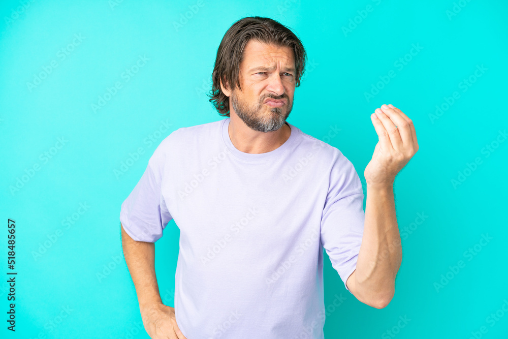 Senior dutch man isolated on blue background making Italian gesture Senior dutch man isolated on blue background making Italian gesture