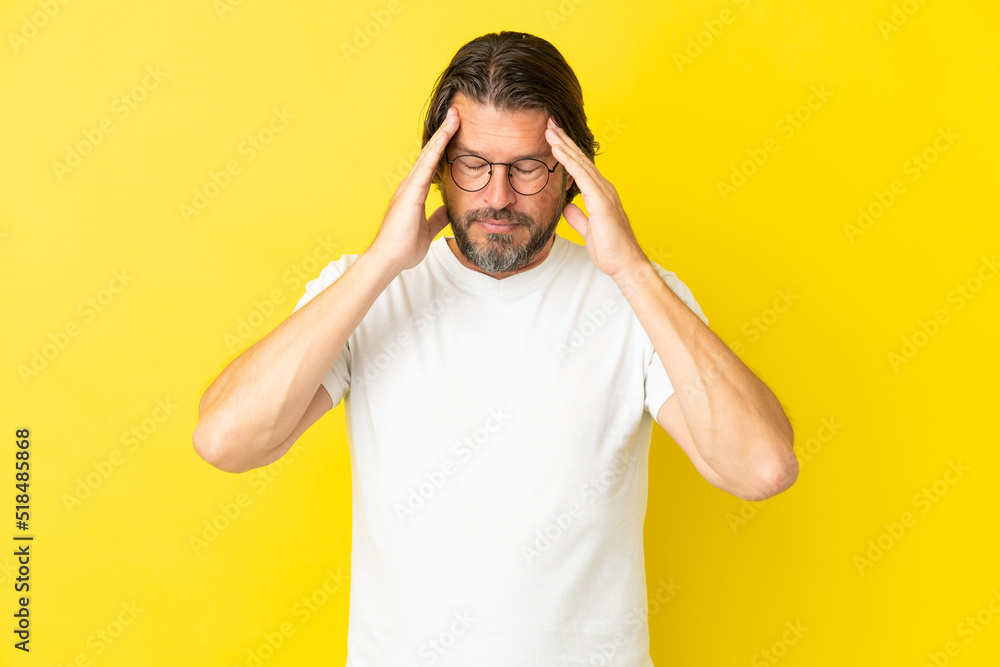 Senior dutch man isolated on yellow background with headache Senior dutch man isolated on yellow background with headache