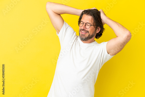 Senior dutch man isolated on yellow background laughing