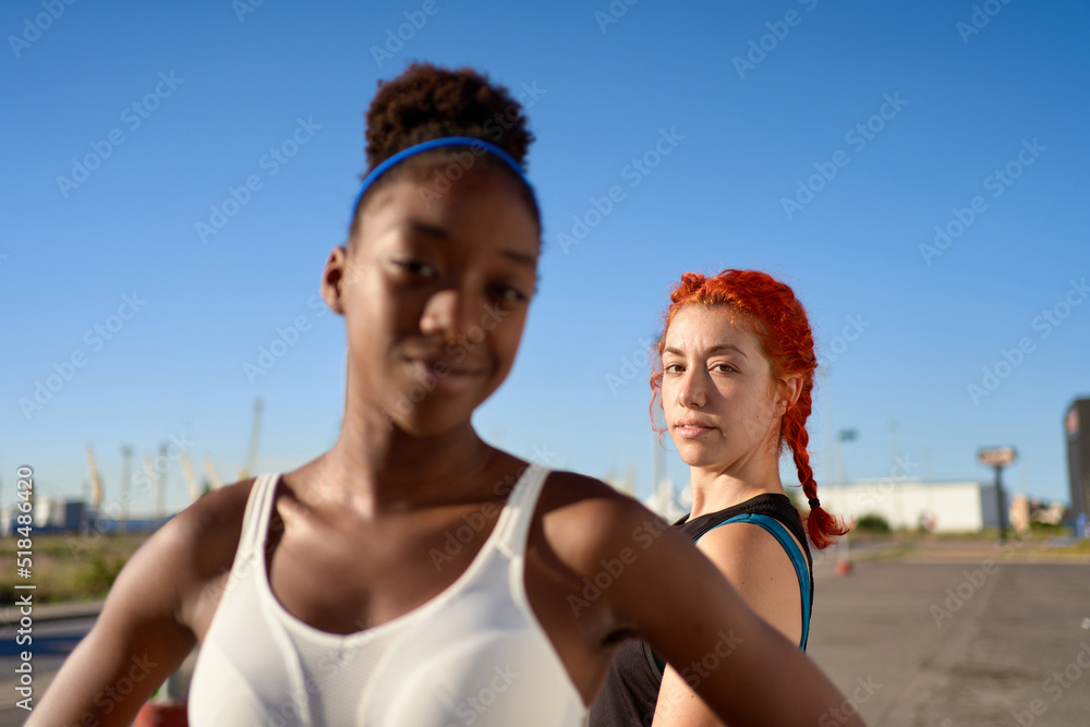 Trendy diverse sportswomen looking at camera on street Trendy diverse sportswomen looking at camera on street