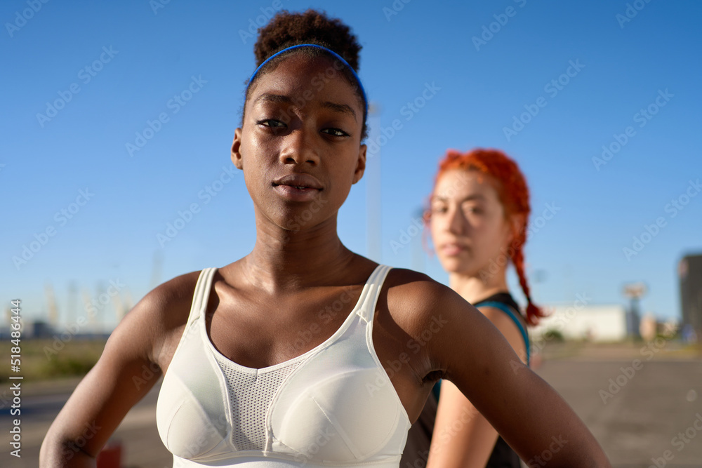 Trendy diverse sportswomen looking at camera on street Trendy diverse sportswomen looking at camera on street