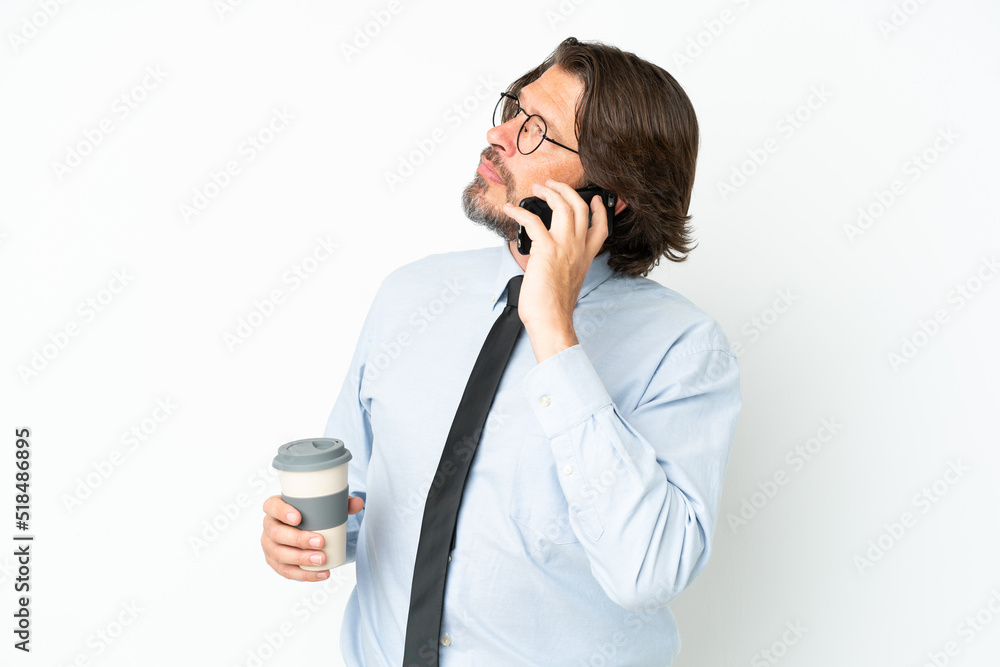 Senior dutch business man isolated on white background holding coffee to take away and a mobile Senior dutch business man isolated on white background holding coffee to take away and a mobile