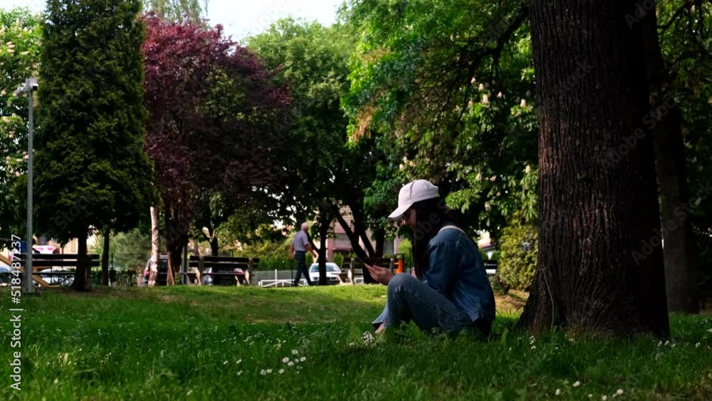 woman sitting in summer public park under the tree reading book woman sitting in summer public park under the tree reading book
