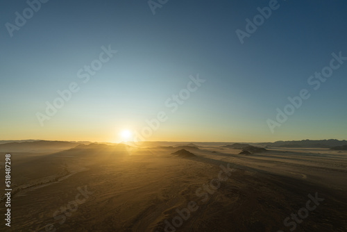Sunrise seen from a hot air balloon during a ride in Sossusvlei, Namibia. sunbeams shine over the hills and mountains of the Namib-Desert.