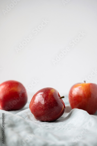 Red apples in front of white photo