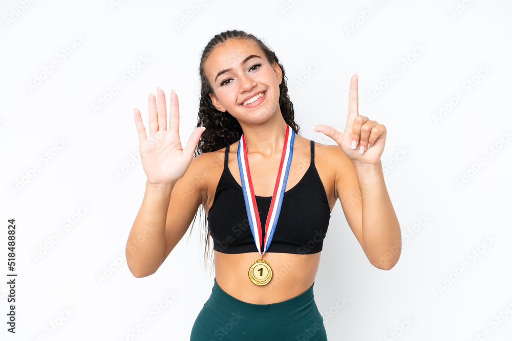 Young sport woman with medals isolated on white background counting seven with fingers