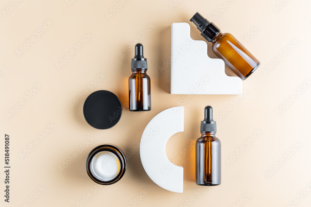 anti-aging collagen facial serum in dark glass bottle and face cream on beige background with concrete podiums. Natural Organic Cosmetic Beauty Concept. anti-aging collagen facial serum in dark glass bottle and face cream on beige background with concrete podiums. Natural Organic Cosmetic Beauty Concept.