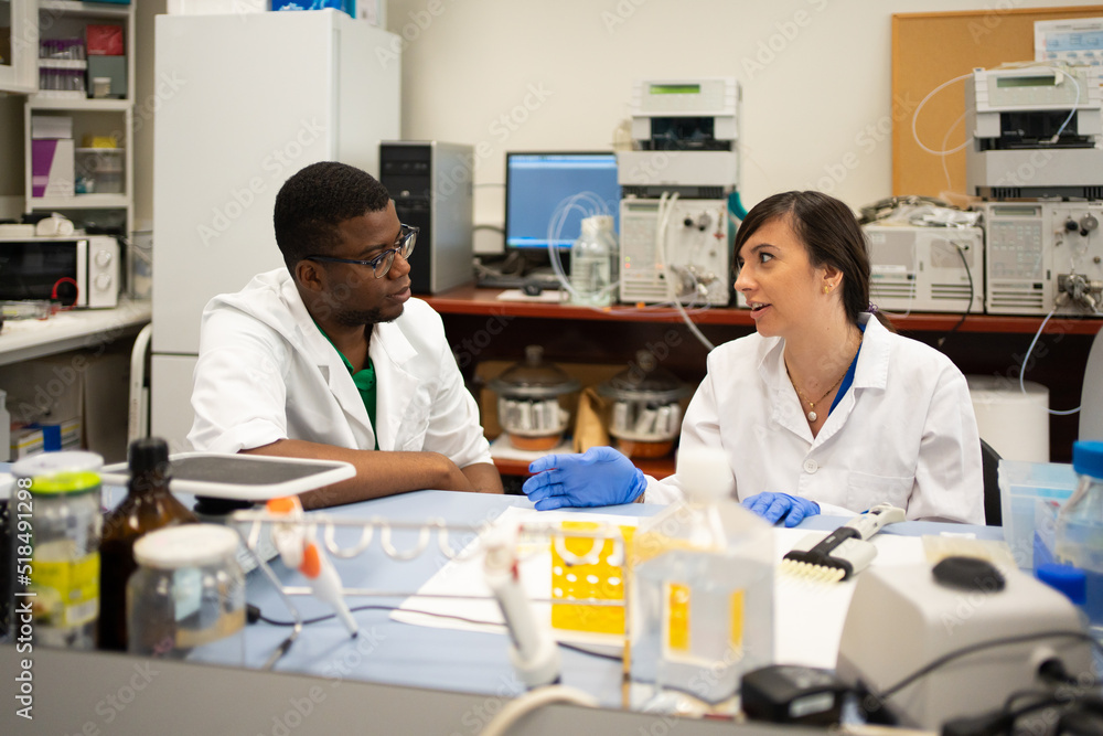 Multiracial Scientists Researching And Talking In The Laboratory. Multiracial Scientists Researching And Talking In The Laboratory.