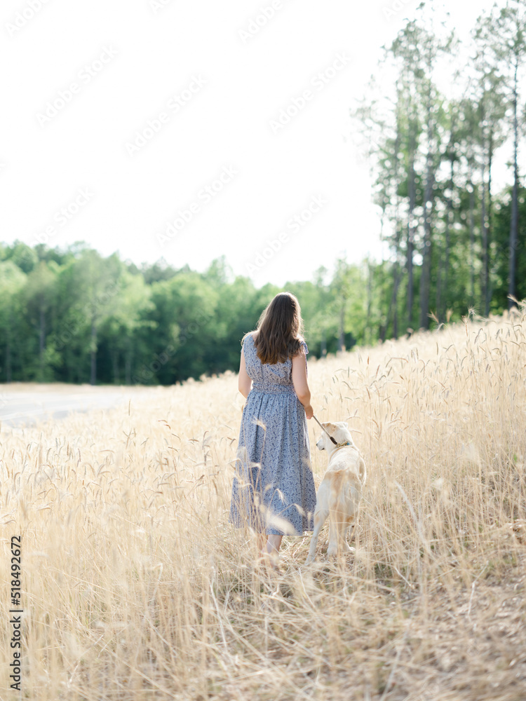 A young woman in a wheat field with her dog A young woman in a wheat field with her dog