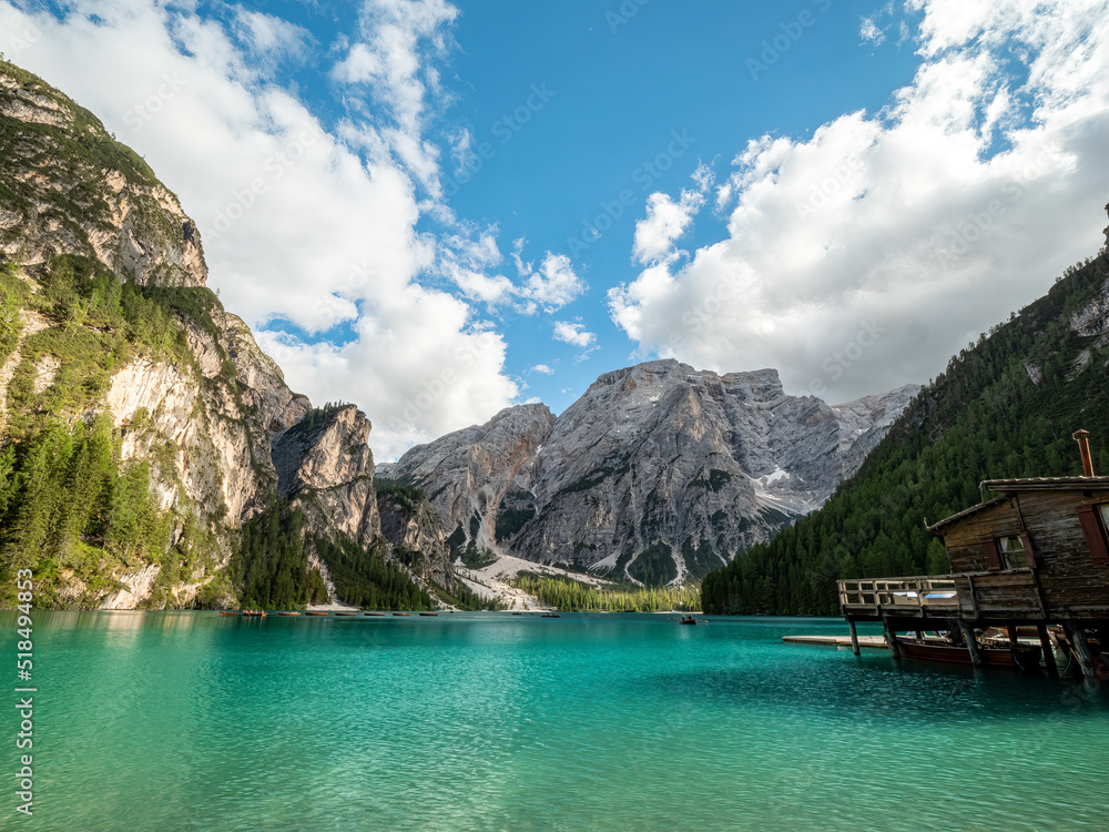 The most famous crystal clear mountain lake at the Dolomites during summer with mountain scenery at the background