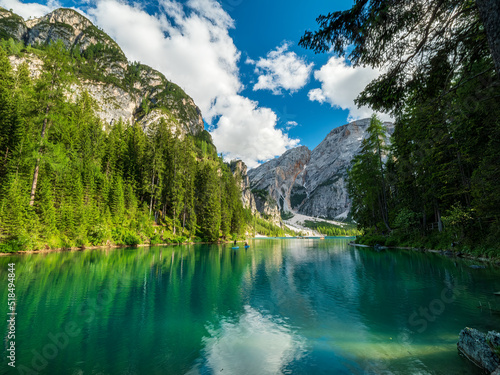The most famous crystal clear mountain lake at the Dolomites during summer with mountain scenery at the background