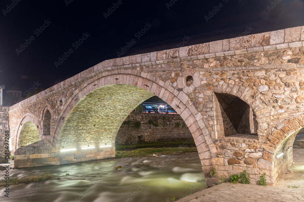 The Old Stone Bridge crosses the Prizrenska Bistrica river at night.