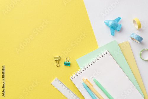 Back to school concept. Top view photo of colorful school supplies plane shaped sharpener pens ruler adhesive tape and binder clips on bicolor yellow and white background