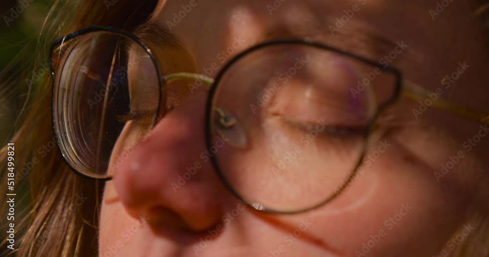 Close up of girl`s eyes in glasses closing in serenity of beautiful windy weather. Close up of girl`s eyes in glasses closing in serenity of beautiful windy weather.