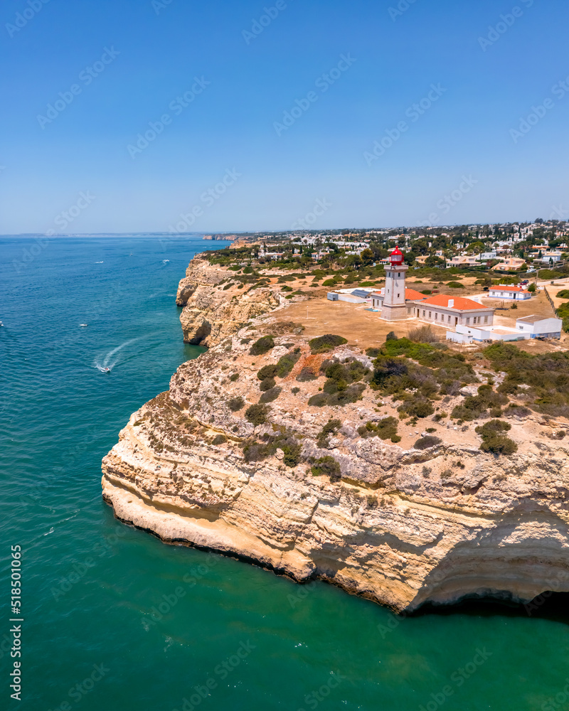 Aerial view of the Alfanzina Lighthouse on the Lagoa coast in Portugal over the Atlantic Ocean