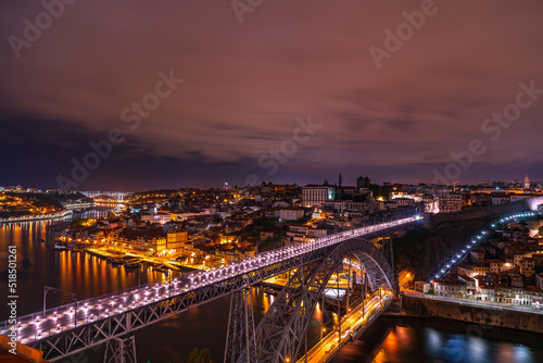 Night photo of the top of the old town and the Dom Luis Bridge over the Douro River. Beautifully illuminatedcity ​​of Porto, Portugal
