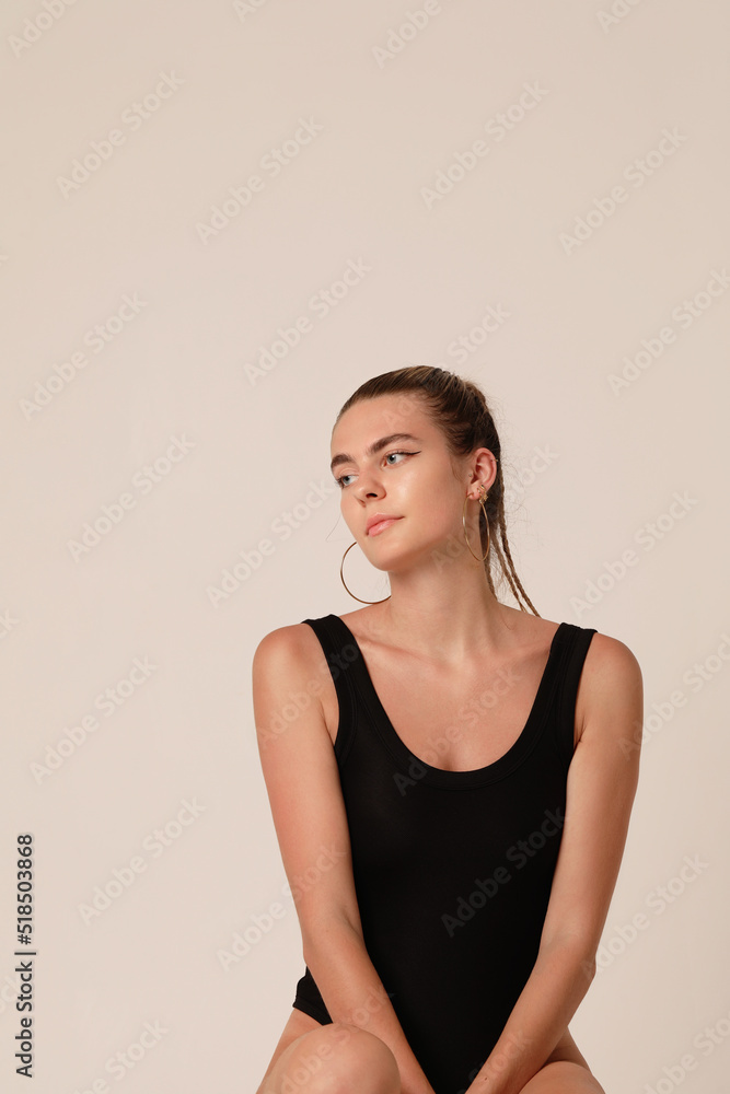 Cute young caucasian woman in black body posing in the studio. Vertical. Cute young caucasian woman in black body posing in the studio. Vertical.