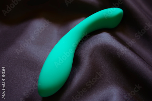 Grüner Dildo auf Schwarzen Satin
