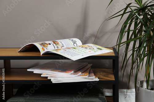 Fototapeta Wooden cabinet with magazines near houseplant indoors