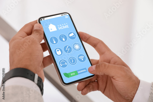 Wallpaper Mural Man using Smart Home app on mobile phone indoors, closeup Torontodigital.ca