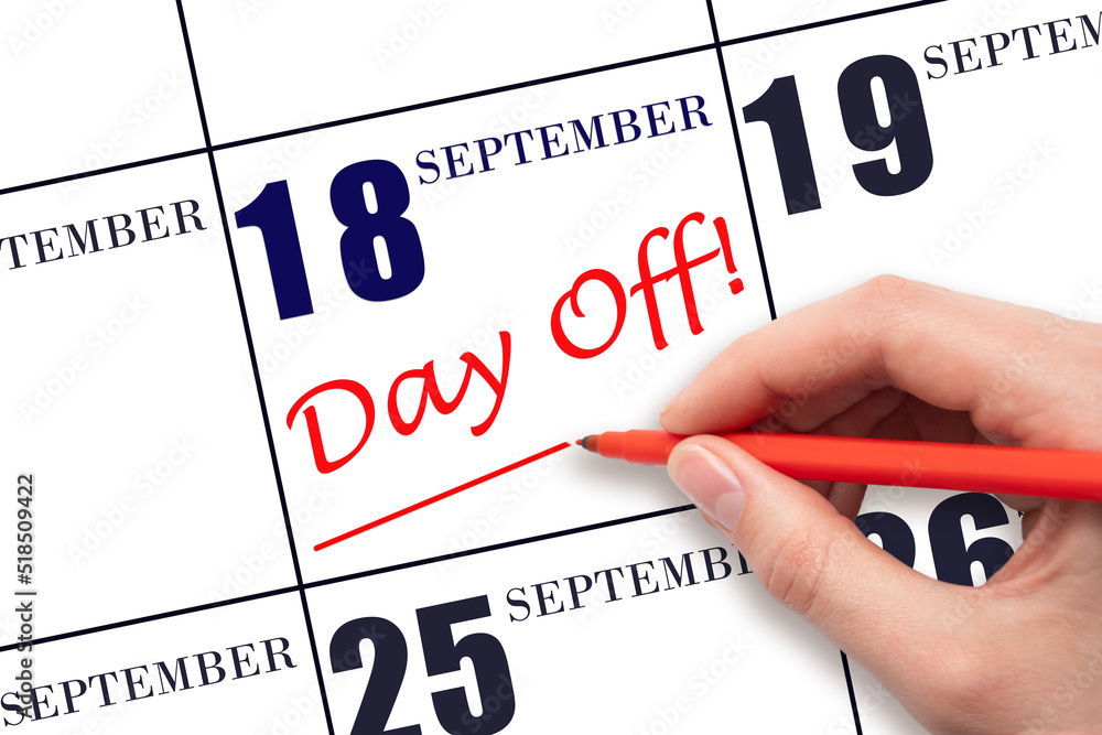 Hand writing text DAY OFF and drawing a line on calendar date 18 September . Vacation planning concept. Hand writing text DAY OFF and drawing a line on calendar date 18 September . Vacation planning concept.