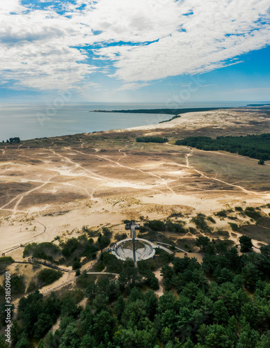 Drone picture of One of the most famous dunes in Lithuania, mass of sand created this unique landscape beside baltic sea, sun clock is installed on the side of the dune photo