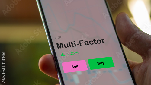 An investor's analizing the multi-factor etf fund on a screen. A phone shows the prices of multi factor and multifactor 