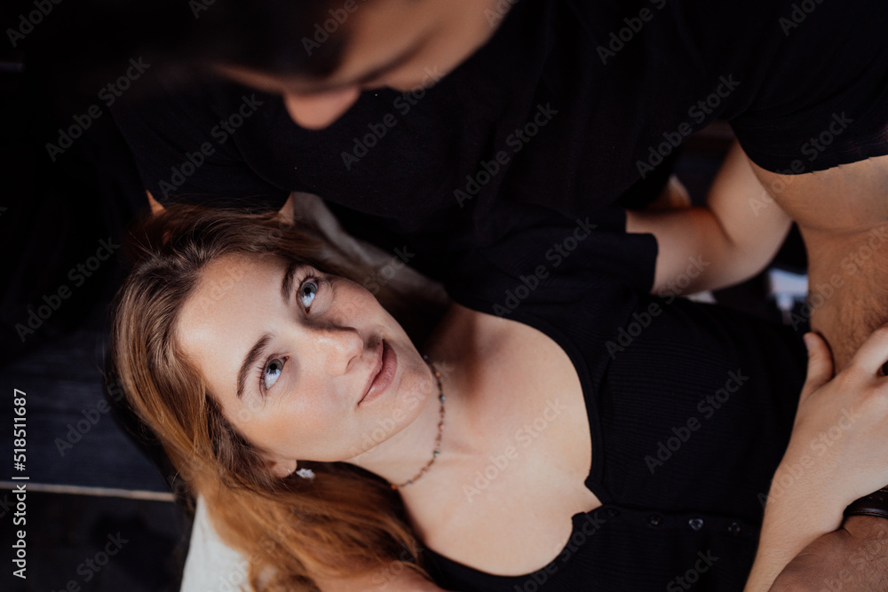 Close up from top of young blonde Italian female with wavy hair in black blouse laying on her boyfriends knees, looking adorable at him. Couple spending time together on valentine's day. Loving people Close up from top of young blonde Italian female with wavy hair in black blouse laying on her boyfriends knees, looking adorable at him. Couple spending time together on valentine's day. Loving people