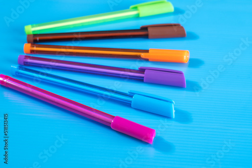 Color pens lying on blue background