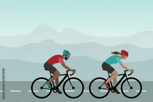 Two cyclists riding on the road. Man and woman on bicycles, mountain landscape in the background.