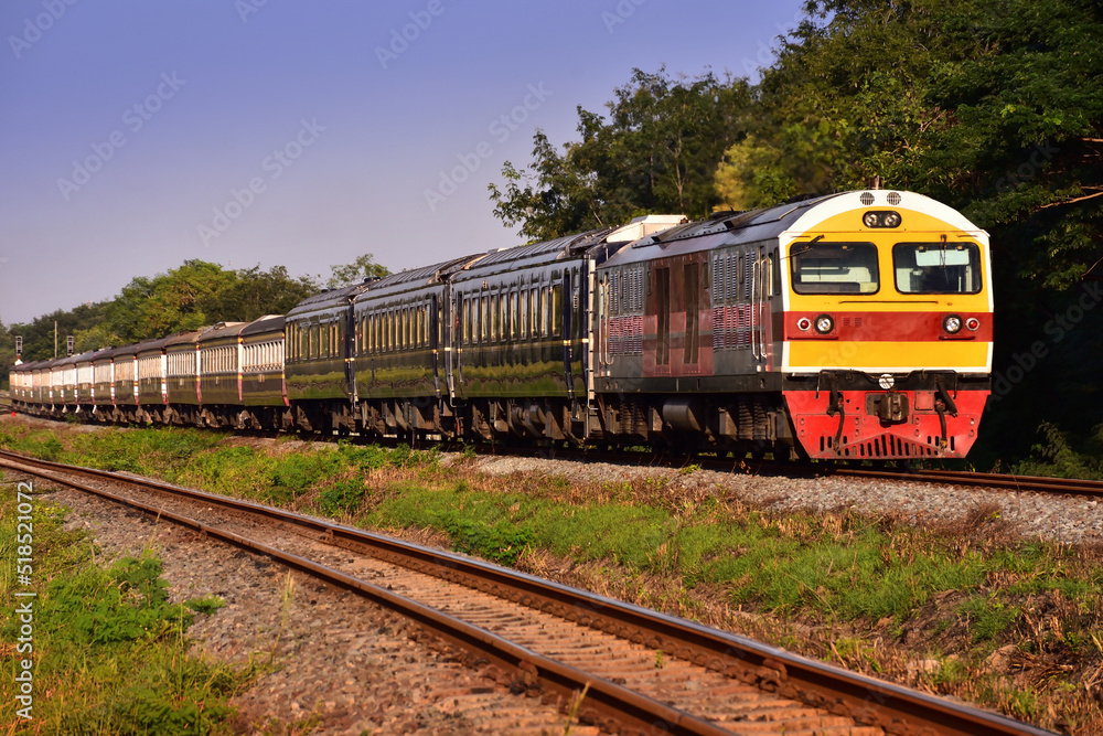 Passenger train by diesel locomotive on the railway in Thailand