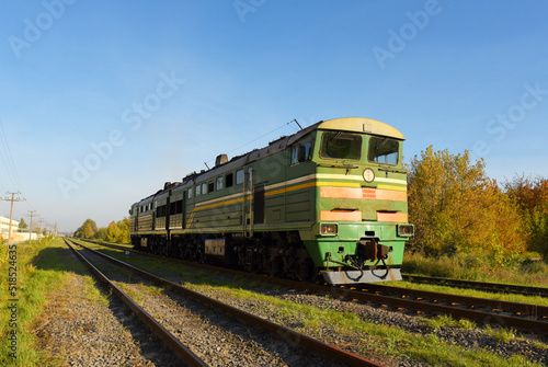 Train locomotive rides on rails. Diesel freight train on railroad in motion. The head of a heavy diesel tractor locomotive for transporting train wagons.