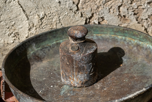 Selective focus shot of iron kilogram scale placed in old metal container.