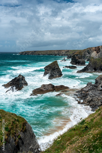 portrait view of bedruthan steps pillars rocks and the blue water and waves around them