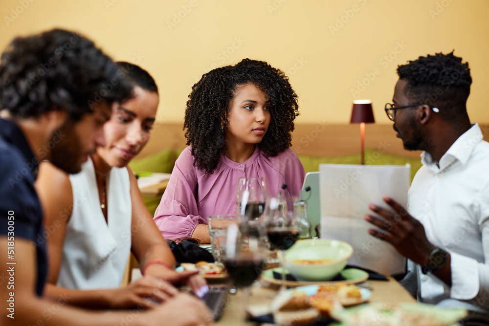 The businesspeople sit in a restaurant and have a business meeting during dinner. The businesspeople sit in a restaurant and have a business meeting during dinner.