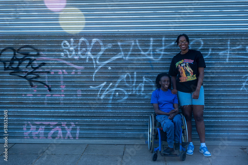 Portrait of smiling teenage girl (16-17) in wheelchair with friend