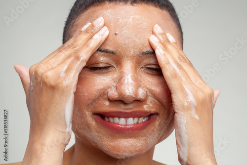 Close-up of smiling woman washing face