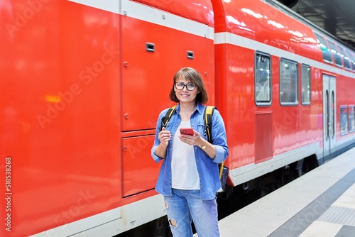 Woman passenger waiting on railway platform inside station