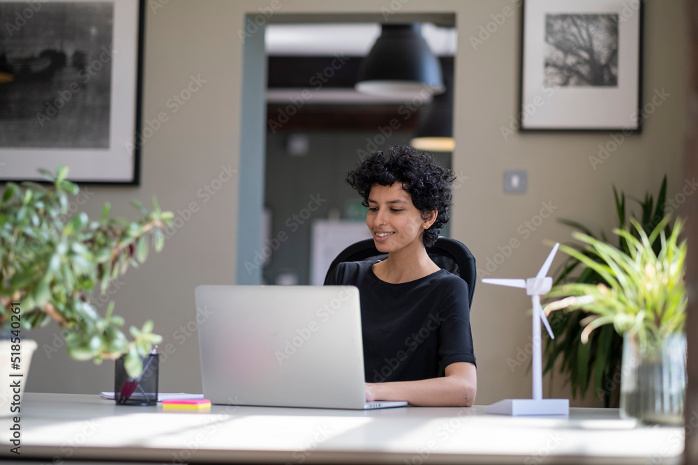 Young engineer working on laptop in office