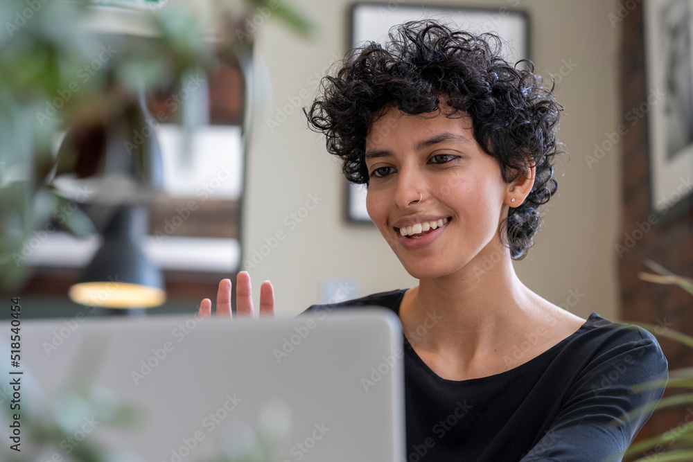 Young woman having video call on laptop in office Young woman having video call on laptop in office