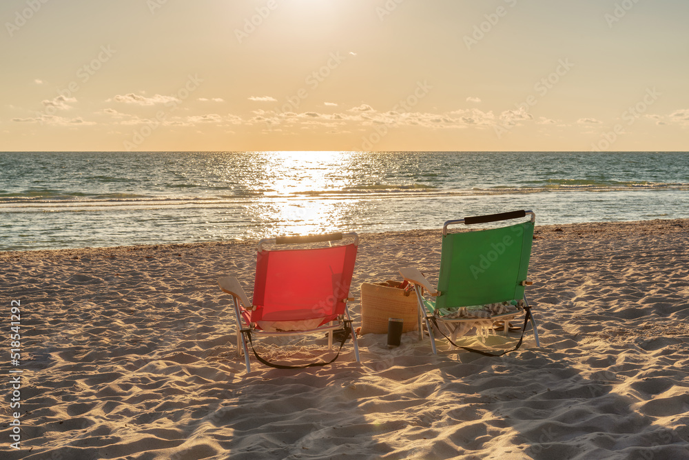 Beach chairs at sunset in tropical beach with accessory. Summer vacation and tropical beach concept. Beach chairs at sunset in tropical beach with accessory. Summer vacation and tropical beach concept.