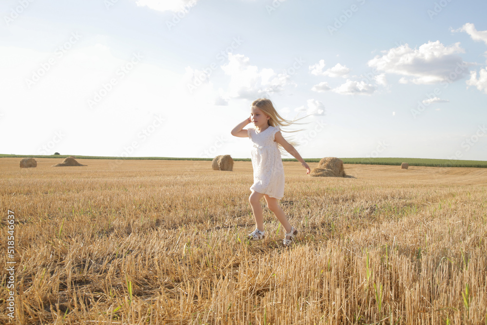 Adorable little girl in white dress in a wheat field Adorable little girl in white dress in a wheat field