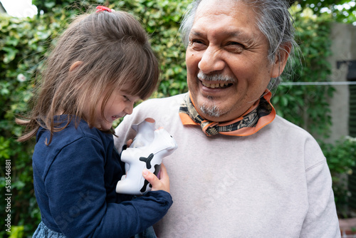 Smiling senior man with granddaughter outdoors photo
