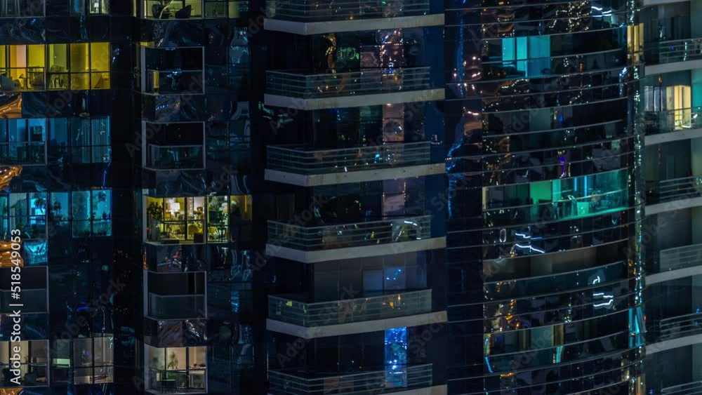 Night view of many glowing windows in apartment residential tower timelapse. High rise skyscraper with lights in rooms. Relax zone on balcony Night view of many glowing windows in apartment residential tower timelapse. High rise skyscraper with lights in rooms. Relax zone on balcony